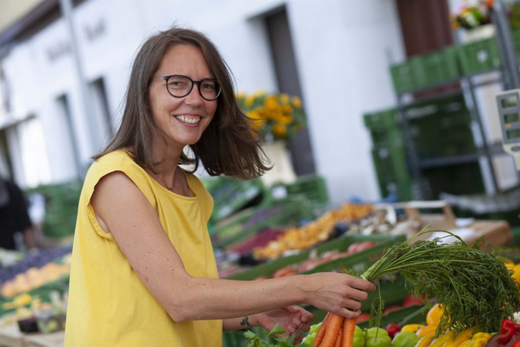 Ernährungsbewusst - Marion Pinterits - Porträt von Marion beim Einkauf auf einem Gemüsemarkt